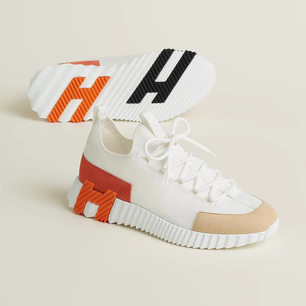Weißer Slip-on-Sneaker aus Strickgewebe mit grauer Wildleder-Zehenkappe, orangefarbenem Bündchen und weißer Profilsohle – Seitenansicht